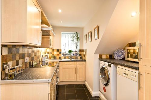 uma cozinha com um lavatório e uma máquina de lavar louça em Juniper Cottage em Bakewell