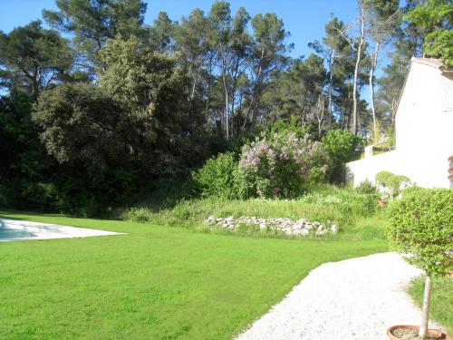a grassy yard with a white house and trees at Bastide de Ganay - Saint Jérôme in Aix-en-Provence