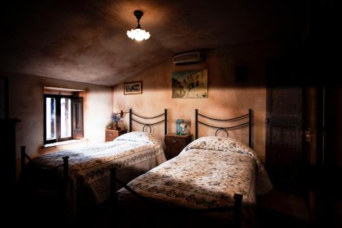 two beds in a dark room with a window at Locanda della Casella in Cineto Romano