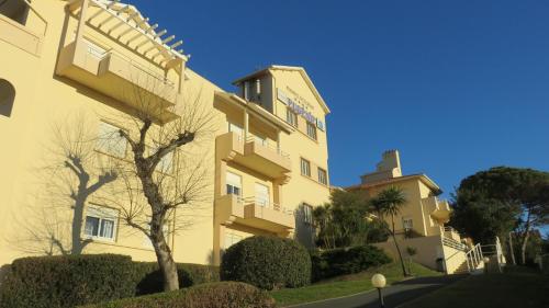 a yellow building with a tree in front of it at Résidence Mer & Golf Eugénie in Biarritz