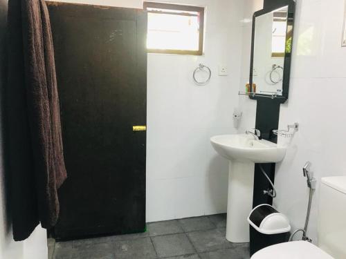 a bathroom with a black door and a sink at VILLA 826 Ahungalla in Ahungalla
