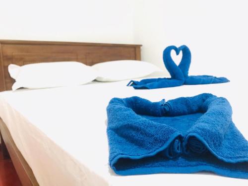 a bed with two blue towels on it at VILLA 826 Ahungalla in Ahungalla