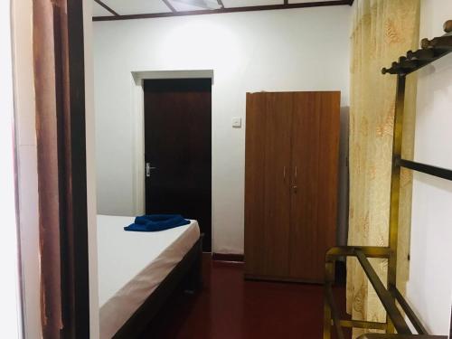 a bedroom with a bed and a wooden door at VILLA 826 Ahungalla in Ahungalla