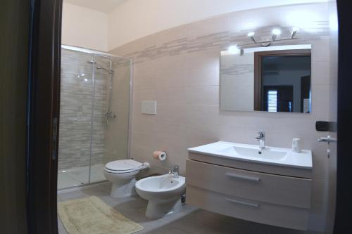 a bathroom with a sink and a toilet and a shower at Bed & breakfast "MAZZINI" in Leverano