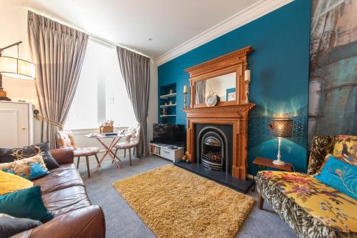 a living room with blue walls and a fireplace at The Jeffrey Street Retreat in Edinburgh