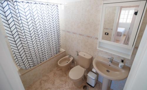 a bathroom with a toilet and a sink at Residencial Arena del Sol 6 by Olax Rentals in Puerto de Santiago
