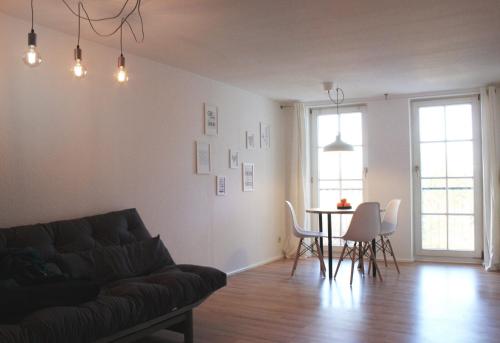 a living room with a couch and a table and chairs at Engen Apartment in Engen
