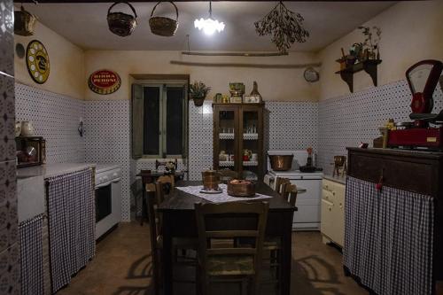 eine Küche mit einem Tisch und einigen Stühlen in der Unterkunft Locanda della Casella in Cineto Romano