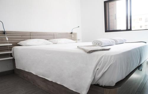 Una cama blanca con dos toallas encima. en Fayser FREE WIFI, en Los Cristianos