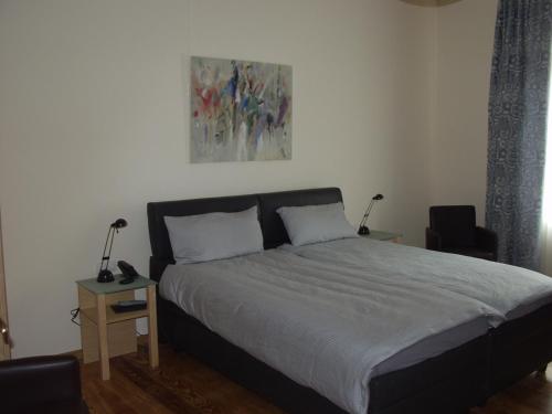1 dormitorio con 1 cama y una pintura en la pared en Exklusive Gästezimmer Landau en Landau in der Pfalz