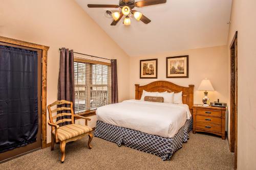 a bedroom with a bed and a chair and a window at The Lodges of the Great Smoky Mountains in Pigeon Forge