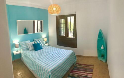 プエルト・デ・サンティアゴにあるElita el varadero FREE WIFIの青いベッドルーム(ベッド1台、鏡付)