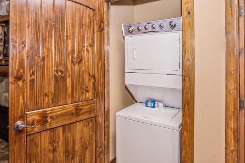 een badkamer met een wasmachine en droger naast een deur bij The Lodges of the Great Smoky Mountains by Capital Vacations in Pigeon Forge