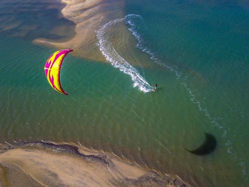 a person flying a kite in the water on the beach at Refúgios Parajuru - Villa Cristiano in Parajuru