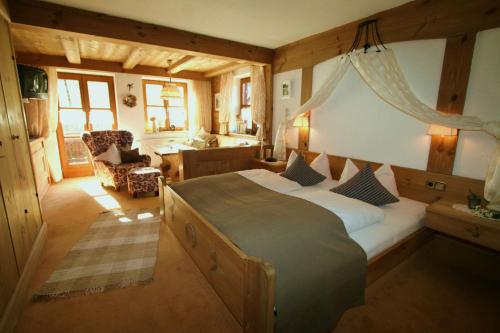 a bedroom with a bed and a desk in a room at Das Landhaus in Pfronten