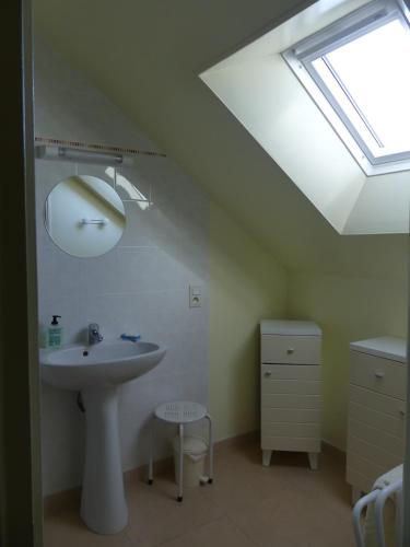 La salle de bains est pourvue d'un lavabo et d'une lucarne. dans l'établissement Gite à la ferme de La poterie, à Donnery