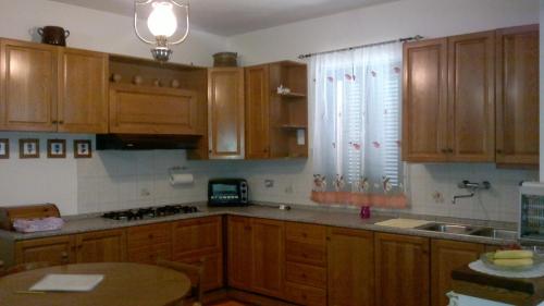una cocina con armarios de madera y una mesa. en Villa L'Oliveto, en Trevi