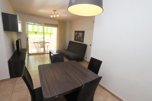 Un comedor con una mesa y sillas y un sofá. en DIFFERENTFLATS Decathlon, en Salou