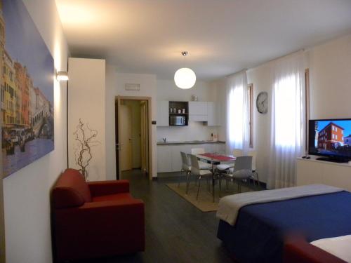 1 dormitorio con 1 cama y sala de estar con mesa en Venice Apartments Dante, en Mestre