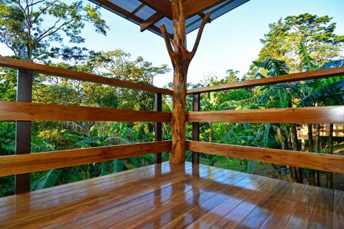a wooden deck with a view of the forest at Aves de Tierras Altas in Bijagua