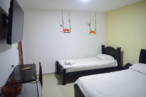 una camera con due letti e una tv di Hotel Intersuites a Barranquilla