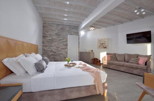 una camera con un grande letto e un divano di Amelie Suites ad Agios Stefanos