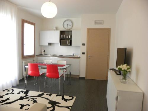 uma cozinha e sala de jantar com mesa e cadeiras vermelhas em Venice Apartments Dante em Mestre
