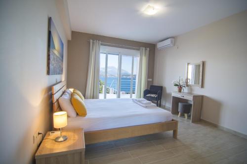 1 dormitorio con cama, escritorio y ventana en Loggos view apartments en Lixouri