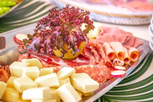 a plate of food with cheese and meats on a table at Refugios Parajuru - Casa Manga in Parajuru