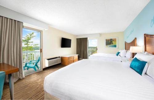 a hotel room with a large bed and a balcony at Margaritaville Lake Resort Lake of the Ozarks in Osage Beach