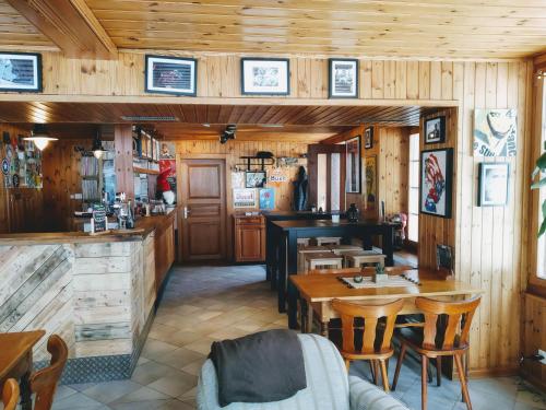 a restaurant with wooden walls and wooden tables and chairs at Hôtel Pension du Lac Bleu in La Gouille