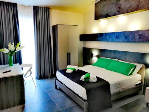 a bedroom with a large bed with green pillows at L'Eden B&B in Santa Domenica