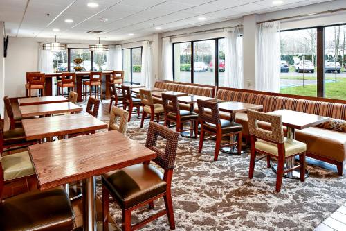 a restaurant with wooden tables and chairs and windows at Best Western Plus Bellingham in Bellingham