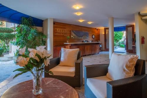 a lobby with chairs and a table with a vase of flowers at Velero Beach Resort in Cabarete