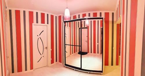 een badkamer met een spiegel in een kamer met strepen bij Stylish apartment on street Ismail 84 in Chişinău