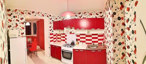 una cocina con armarios rojos y azulejos rojos y blancos en Stylish apartment on street Ismail 84, en Chişinău