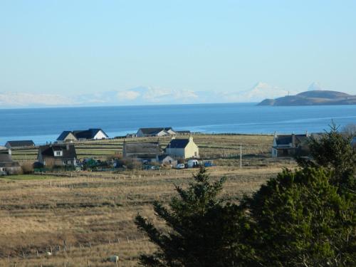 a group of houses in a field next to the water at Wardicott in Back