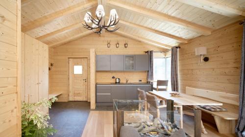 eine Küche mit Holzwänden und ein Esszimmer mit einem Tisch in der Unterkunft La Plates in St. Ulrich in Gröden
