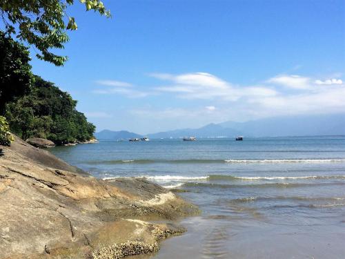 a beach with some boats in the water at Pousada Vistazul - Pé na Areia in Bertioga