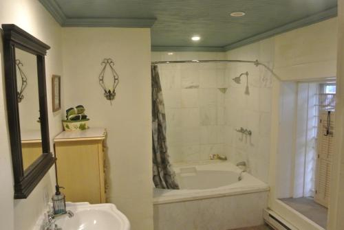a bathroom with a tub and a shower and a sink at Inn at the L C Ranch in Gila