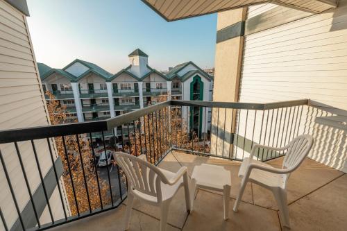 a balcony with two chairs and a table and a building at Carriage Place in Branson
