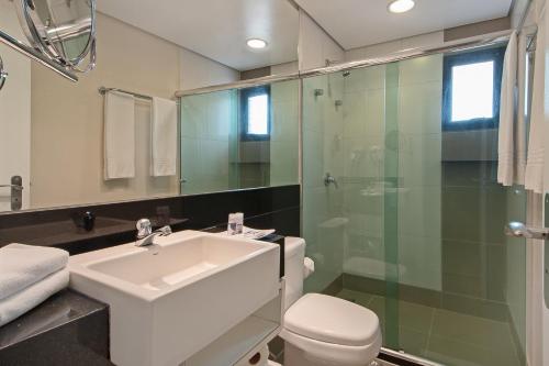 a bathroom with a sink and a toilet and a shower at Hotel Adrianópolis All Suites in Manaus