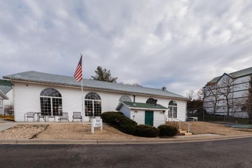 a white building with an american flag in front of it at Carriage Place in Branson