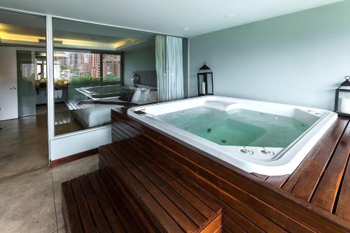 a jacuzzi tub in a large room with at The Charlee Hotel in Medellín
