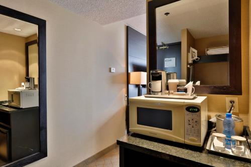 a hotel room with a microwave and a mirror at Edmonton Hotel & Convention Center Edmonton in Edmonton