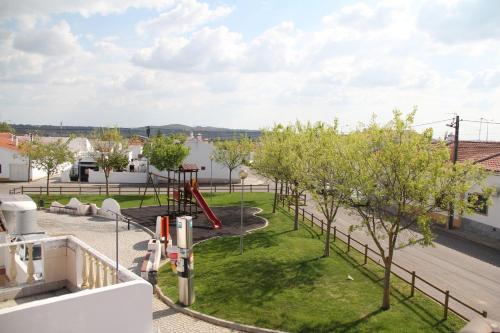 a view of a playground with trees and a slide at Hospedaria O Castelo in Portel