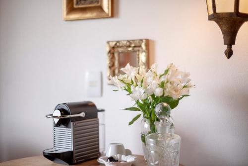 a vase of flowers sitting on top of a table at Alma Hotel in Campos do Jordão