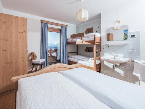 een slaapkamer met een stapelbed en een badkamer met een wastafel bij Rifugio Graziani Hütte in San Vigilio Di Marebbe