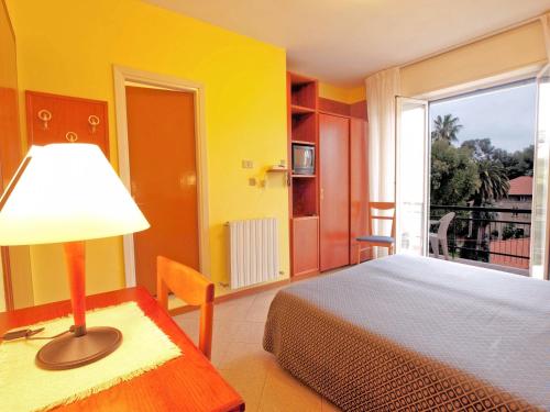 a bedroom with a bed and a large window at Hotel Capri in Diano Marina