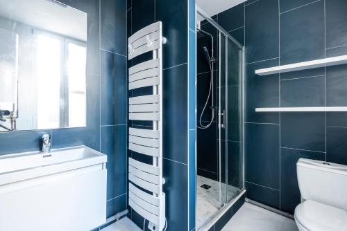 La salle de bains est pourvue d'une douche, de toilettes et d'un lavabo. dans l'établissement MM Suites Marlot, à Reims